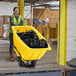 A woman pushing a yellow Lavex tilt truck.