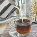 A glass cup of coffee with Elmhurst Milked Oats being poured into it.