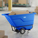 A blue heavy-duty tilt truck or trash cart with a 0.5 cubic yard capacity, loaded with cardboard boxes.