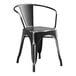 A Lancaster Table & Seating black metal outdoor arm chair with arms.