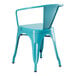 A turquoise metal Lancaster Table & Seating outdoor arm chair on a patio.