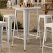 A Lancaster Table & Seating white bar table with stools.