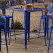 A blue table with a long leg and two blue chairs.