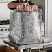 A woman using a Lavex insulated box liner to hold a piece of meat.