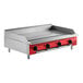 An Avantco red and steel countertop gas griddle with thermostatic controls.