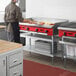 A man using an Avantco Chef Series countertop gas griddle to cook food in a professional kitchen.