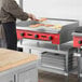 A man using an Avantco countertop gas griddle to cook.