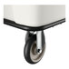 A close-up of a caster wheel attached to the bottom of a white leakproof cube truck.