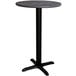 A round Lancaster Table & Seating counter height table with a black base and grey marble top.