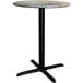 A Lancaster Table & Seating round counter height table with a black base.