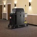 A black Suncast housekeeping cart in a hallway.