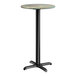 A round bar height table with a textured canyon painted faux metal finish top and a black cross base plate.
