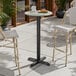 A round bar height table with a textured faux metal finish and a cross base plate.
