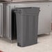 A gray Suncast slim rectangular trash can with handles.