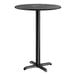 A round bar height table with a black smooth finish top and a black cross base plate.