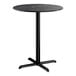 A round bar height table with a black smooth finish top and a black cross base plate.