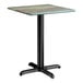 A square standard height table with a textured canyon painted faux metal finish top and a black cross base plate.