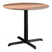 A round standard height table with a textured farmhouse finish top and a black cross base plate.