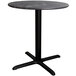 A Lancaster Table & Seating round dining table with a black metal base.