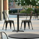 A black chair and table on an outdoor patio.