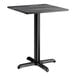A square standard height table with a smooth black finish and a cross base plate.