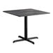 A square standard height table with a smooth black finish and a cross base plate.