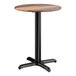 A round standard height table with a textured farmhouse finish and a black cross base plate.