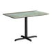 A rectangular standard height table with a textured canyon painted faux metal finish top and a black cross base plate.
