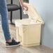 A person cleaning a Lavex rectangular step-on trash can with a white cloth.