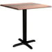 A Lancaster Table & Seating Excalibur square dining table with a black base and textured wooden top.