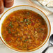 A bowl of Knorr vegetable soup with a spoon on the side.