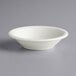 A close up of a Tuxton eggshell white china fruit bowl.