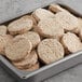 A metal pan filled with Beyond Meat plant-based vegan breakfast sausage patties.