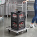 A woman pushing a Vesture aluminum folding cart with two baskets.