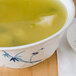 A bowl of soup with a spoon on a white background.