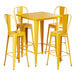 A Lancaster Table & Seating citrine yellow metal bar table with yellow chairs.