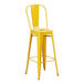 A Lancaster Table & Seating yellow metal outdoor barstool with a seat.