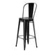 A black metal bar stool with a backrest.