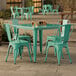 A Lancaster Table & Seating aquamarine table with four chairs on an outdoor patio.