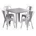 A Lancaster Table & Seating nickel gray metal table with four white chairs around it.