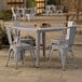 A Lancaster Table & Seating outdoor table with four chairs on a patio.