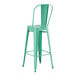 A green barstool with a metal backrest.