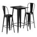 A Lancaster Table & Seating onyx black bar table with two black barstools.