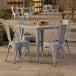 A Lancaster Table & Seating outdoor table with four chairs on a patio.