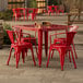 A Lancaster Table & Seating outdoor table with red chairs.