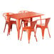 An orange Lancaster Table & Seating metal dining table and 4 chairs on an outdoor patio.