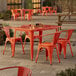 An orange table with chairs on a patio.