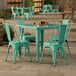 A Lancaster Table & Seating aquamarine table with four green chairs outside.