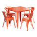 An outdoor Lancaster Table & Seating table and chairs set with an orange metal table and chairs.