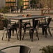 A Lancaster Table & Seating outdoor table with chairs on a patio.